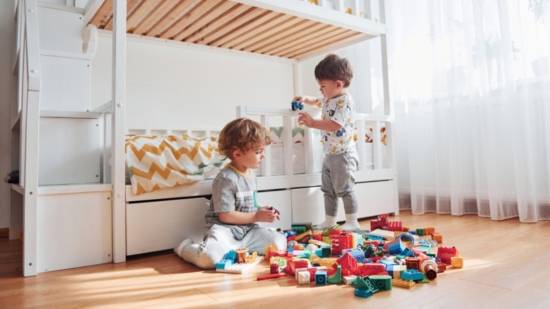 dwóch chłopców bawi się na podłodze w pokoju dziecięcym