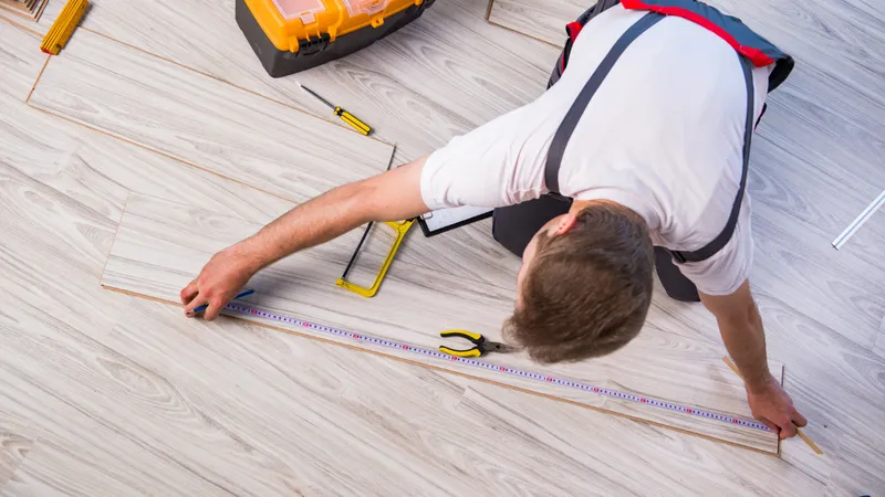 mężczyzna mierzący panel przed przycięciem