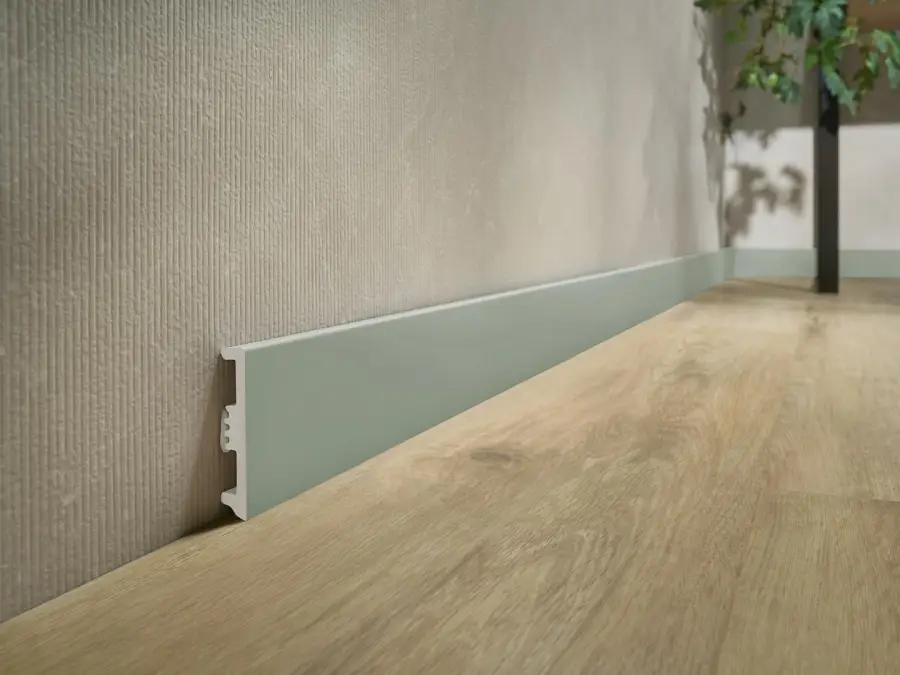 listwa przypodłogowa Stiq-xl szałwia zamontowana do szarej ściany z Modee